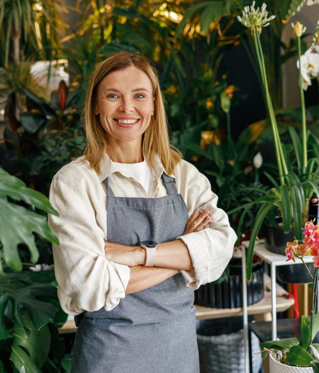Woman florist small business owner standing with crossed arms in floral store. High quality photo